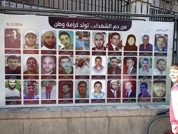 Photos of martyrs displayed on a street in Al-Midan, Damascus, honoring those who gave their lives for the Syrian revolution.