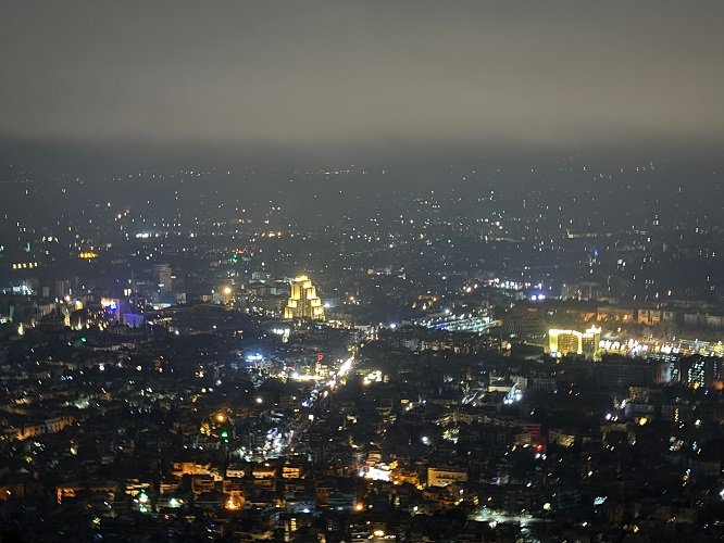 Panoramic view of Damascus, Syria, seen from Mount Qasioun, showing a minarets, historical buildings, and residential areas stretching out to the distant plains under a clear sky